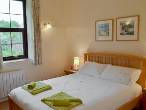 Garden Cottage - Cp28 في Halwell: غرفة نوم عليها سرير وفوط