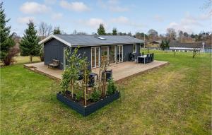 a tiny house in a yard with a deck at Amazing Home In Prst With Kitchen in Præstø