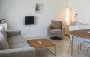 a living room with a couch and a chair and a table at Beautiful Apartment In Gudhjem With 1 Bedrooms, Wifi And Outdoor Swimming Pool in Gudhjem