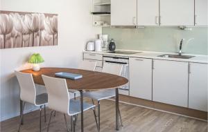 a kitchen with a wooden table and white cabinets at Beautiful Apartment In Gudhjem With 1 Bedrooms, Wifi And Outdoor Swimming Pool in Gudhjem