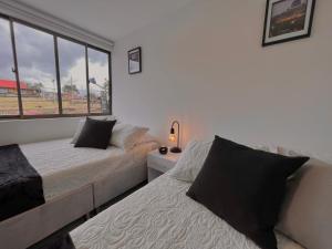 a bedroom with two beds and a window at Acogedor Moderno Tranquilo Wifi Disponible in Villamaría