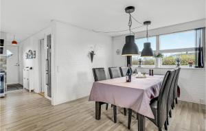 una sala da pranzo con un tavolo e alcune luci nere di 3 Bedroom Nice Home In Nordborg a Nordborg
