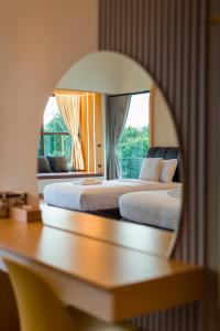 2 bedden in een hotelkamer met een raam bij Family Room by 233Poshtel in Lampang