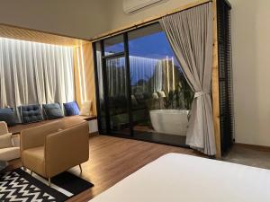 uma sala de estar com uma grande janela e uma banheira em Family Room by 233Poshtel em Lampang