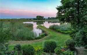 a view of a pond in a field with flowers at 1 Bedroom Amazing Home In Policko 