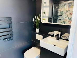 a bathroom with a white sink and a toilet at Respiro Del Mar - Beachfront Superior Apartment in L'Ametlla de Mar +43 photos