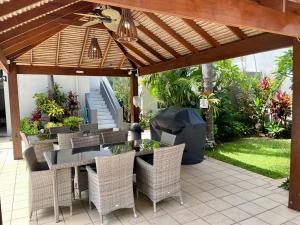 a patio with a table and chairs under a pergola at Burleigh Palms Holiday Apartments in Gold Coast