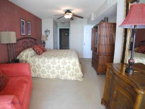 een slaapkamer met een bed en een rode bank bij South Shore 1203 condo in Myrtle Beach