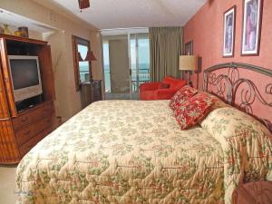 een slaapkamer met een groot bed en een televisie bij South Shore 1203 condo in Myrtle Beach