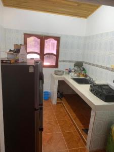 cocina con nevera negra y fregadero en HOSTAL ESPERANZA, en Palomino