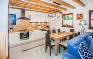 a kitchen and dining room with a table and a blue couch at Cozy Home In Sarbinowo With Wifi in Sarbinowo