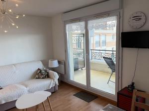 uma sala de estar com um sofá e uma porta de vidro deslizante em Appartement Dives-sur-Mer, 2 pièces, 4 personnes - FR-1-794-74 em Dives-sur-Mer