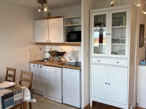 uma cozinha com armários brancos e uma bancada em Appartement Dives-sur-Mer, 2 pièces, 4 personnes - FR-1-794-74 em Dives-sur-Mer