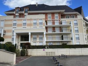 um grande edifício de apartamentos com estacionamento em Appartement Dives-sur-Mer, 2 pièces, 4 personnes - FR-1-794-74 em Dives-sur-Mer