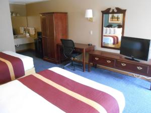 a hotel room with two beds and a desk and a mirror at SureStay by Best Western Cameron in Cameron
