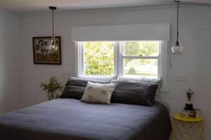 a bedroom with a large bed with a window at Woolbrook Cottage - Charming 1890's Heritage in Taralga