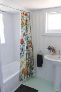 a bathroom with a shower curtain and a sink at Woolbrook Cottage - Charming 1890's Heritage in Taralga