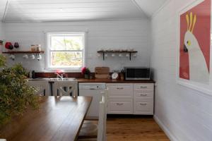 a kitchen with a table and a kitchen with a counter top at Woolbrook Cottage - Charming 1890's Heritage in Taralga