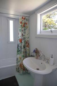 a white bathroom with a sink and a window at Woolbrook Cottage - Charming 1890's Heritage in Taralga