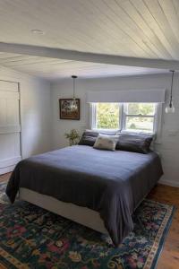 a bedroom with a large bed in front of a window at Woolbrook Cottage - Charming 1890's Heritage in Taralga
