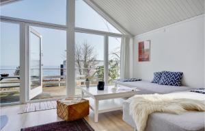 ein Wohnzimmer mit einem Sofa und einem großen Fenster in der Unterkunft Cozy Home In Snekkersten With Kitchen in Snekkersten