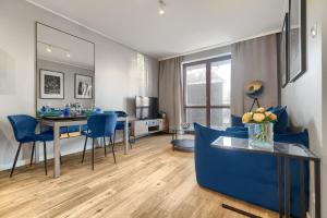 シュチェチンにあるEXCLUSIVE New Town Apartmentsのリビングルーム(青いソファ、テーブル付)