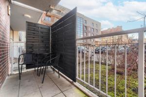 uma varanda com uma cerca preta, uma mesa e cadeiras em EXCLUSIVE New Town Apartments em Szczecin