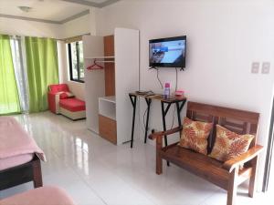 a living room with a couch and a tv on the wall at La Bella Swiss Inn in San Vicente