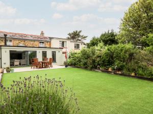 a garden with a lawn in front of a house at Dolwern in Newport