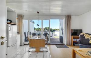 eine Küche und ein Wohnzimmer mit einem Tisch und Stühlen in der Unterkunft Amazing Home In Tranekr With Wifi in Tranekær