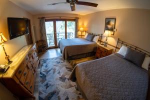 a hotel room with two beds and a television at Narrow Gauge Inn in Fish Camp