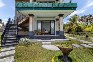 a house with a green roof with a staircase and a yard at Cahaya Ubud Villa in Ubud