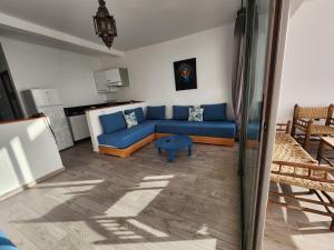 茵蘇宛的住宿－Aloha Imsouane，客厅配有蓝色的沙发和桌子