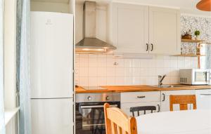 a kitchen with white cabinets and a white refrigerator at Awesome Home In Vrena With Wifi in Vrena