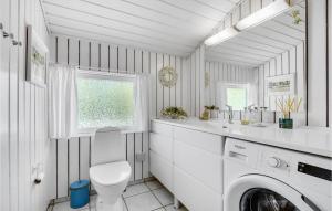 een witte wasruimte met een wasmachine en droger bij Nice Home In Hornbk With Kitchen in Hornbæk