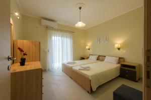 a bedroom with a bed and a large window at Canary Studios in Parga