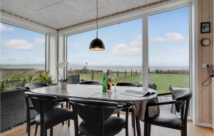 a dining room with a table and chairs and a large window at Amazing Home In Sjølund With Wifi in Sjølund