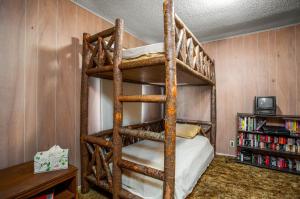 3H Ranch Mountain Retreat في Medina: غرفة نوم مع سرير بطابقين مع سلم
