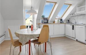 a kitchen and dining room with a table and chairs at Nice Apartment In Svaneke With Wifi in Svaneke