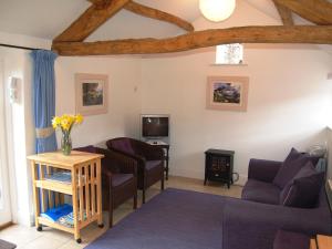 a living room with two couches and a tv at Sycamore Cottage in Ellonby