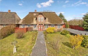 uma casa antiga com um telhado de palha e um caminho em Awesome Home In Hjer With House A Panoramic View em Højer