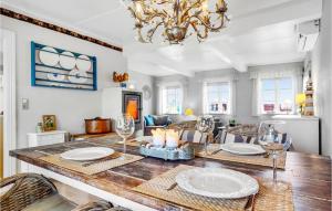 a dining room with a table with chairs and a chandelier at Awesome Home In Hjer With House A Panoramic View in Højer