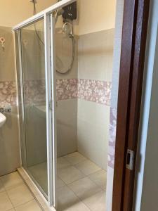 a shower with a glass door in a bathroom at Royal Residency in Kandy