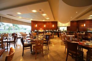 a restaurant with tables and chairs and a chef in the background at Hotel Mercury Inn in Querétaro