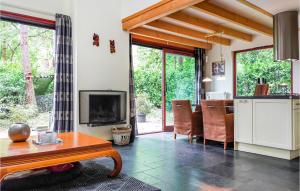 ein Wohnzimmer mit einem TV und einem Tisch sowie eine Küche in der Unterkunft 2 Bedroom Lovely Home In Rekem-lanaken in Bovenwezet