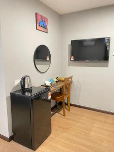 a room with a desk and a television on a wall at RNK BoutiQue HOTEL in Jitra