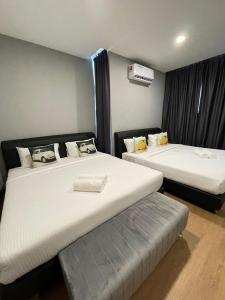 a room with two beds and a bench in it at RNK BoutiQue HOTEL in Jitra