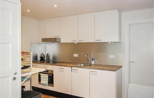 Una cocina con gabinetes blancos y un fregadero. en Klein Maar Fijn, en Bergen