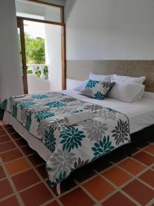 a bed with a blanket and pillows on it at Hotel Santa Fe del Parque in Santa Fe de Antioquia