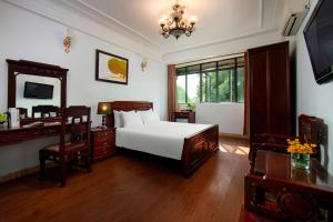 a bedroom with a bed and a desk and a mirror at Hanoi Moonlight Hotel in Hanoi